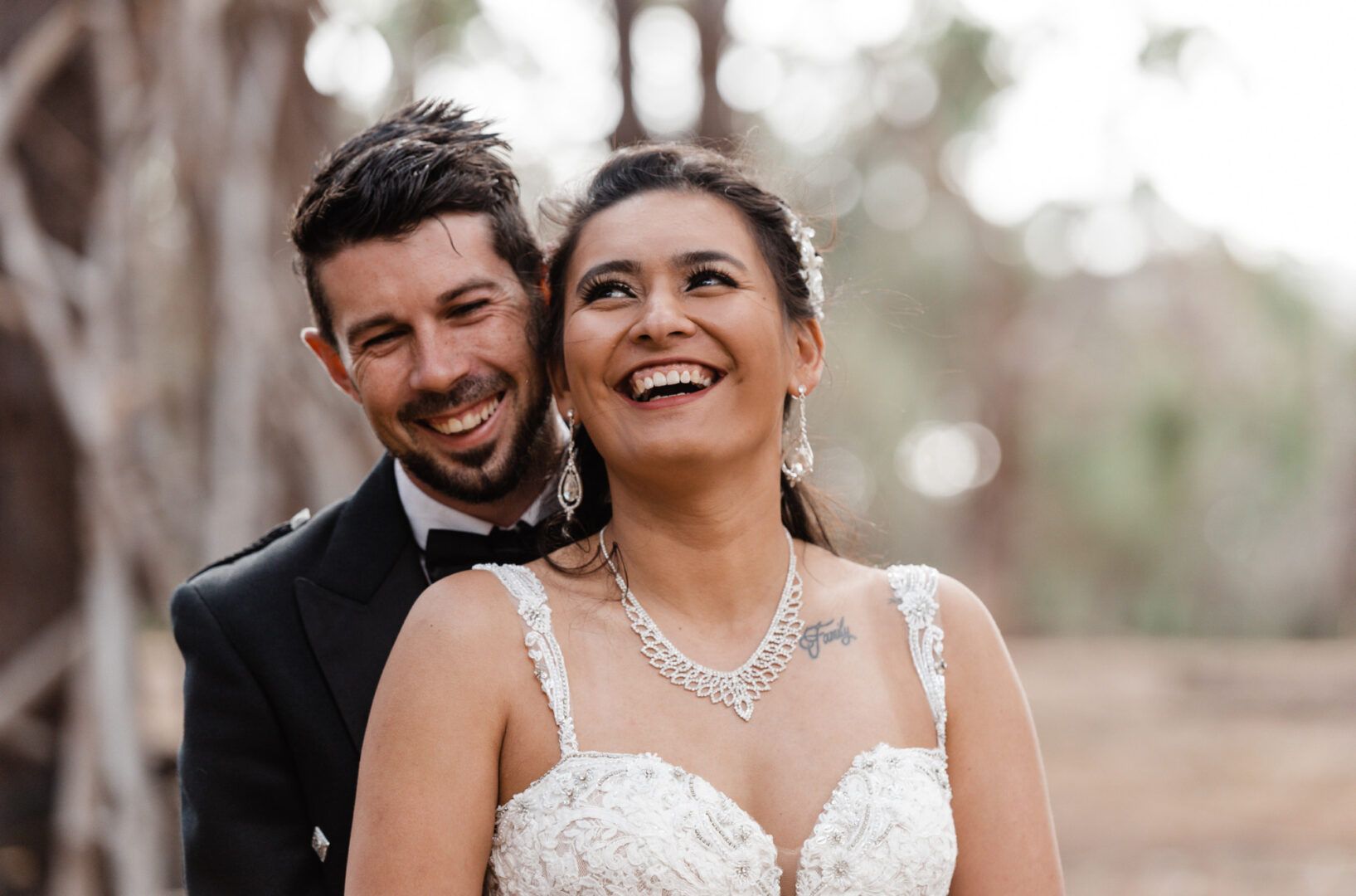 The bride and groom laugh while hugging in a pine forest in Wanneroo Pines, WA.
