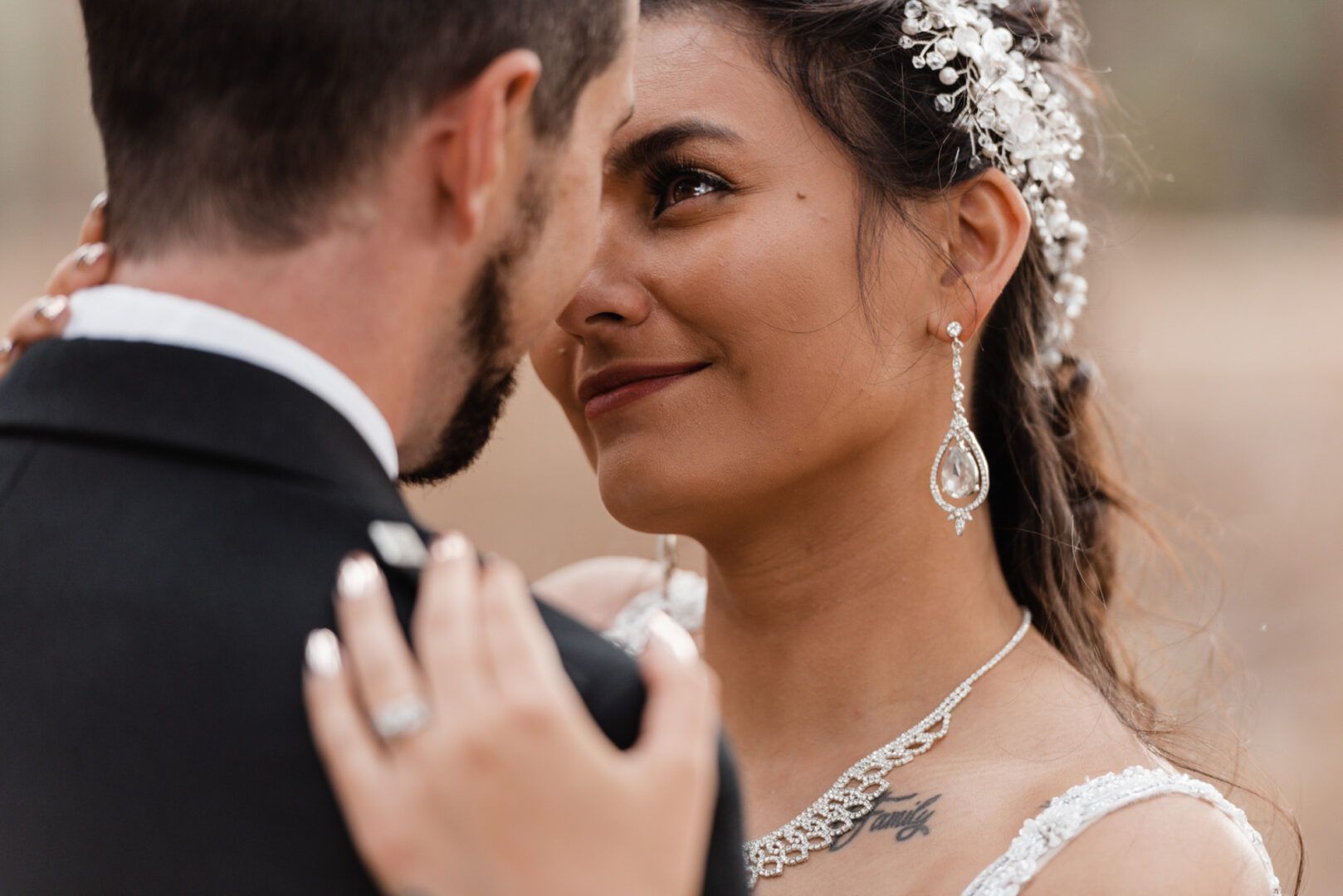 The bride looks into the groom's eyes while hugging him tightly in a field in Wannerroo Pines.