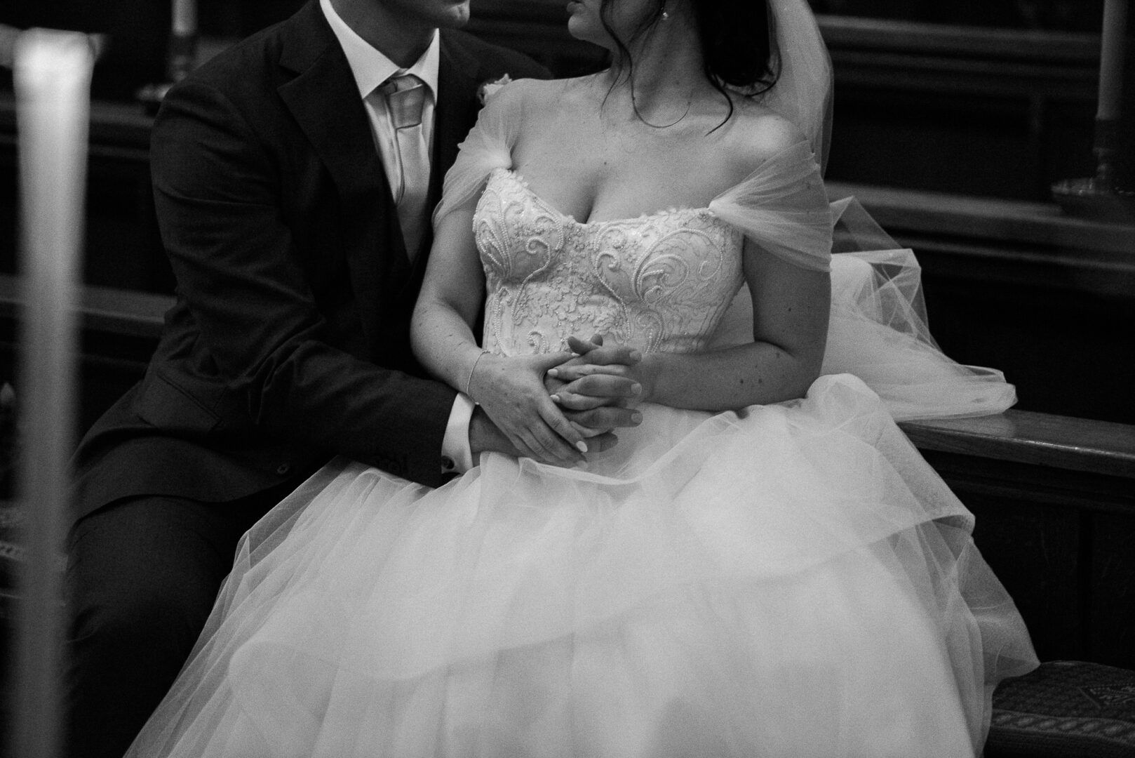 A details shot of the bride and the groom holding hands together.