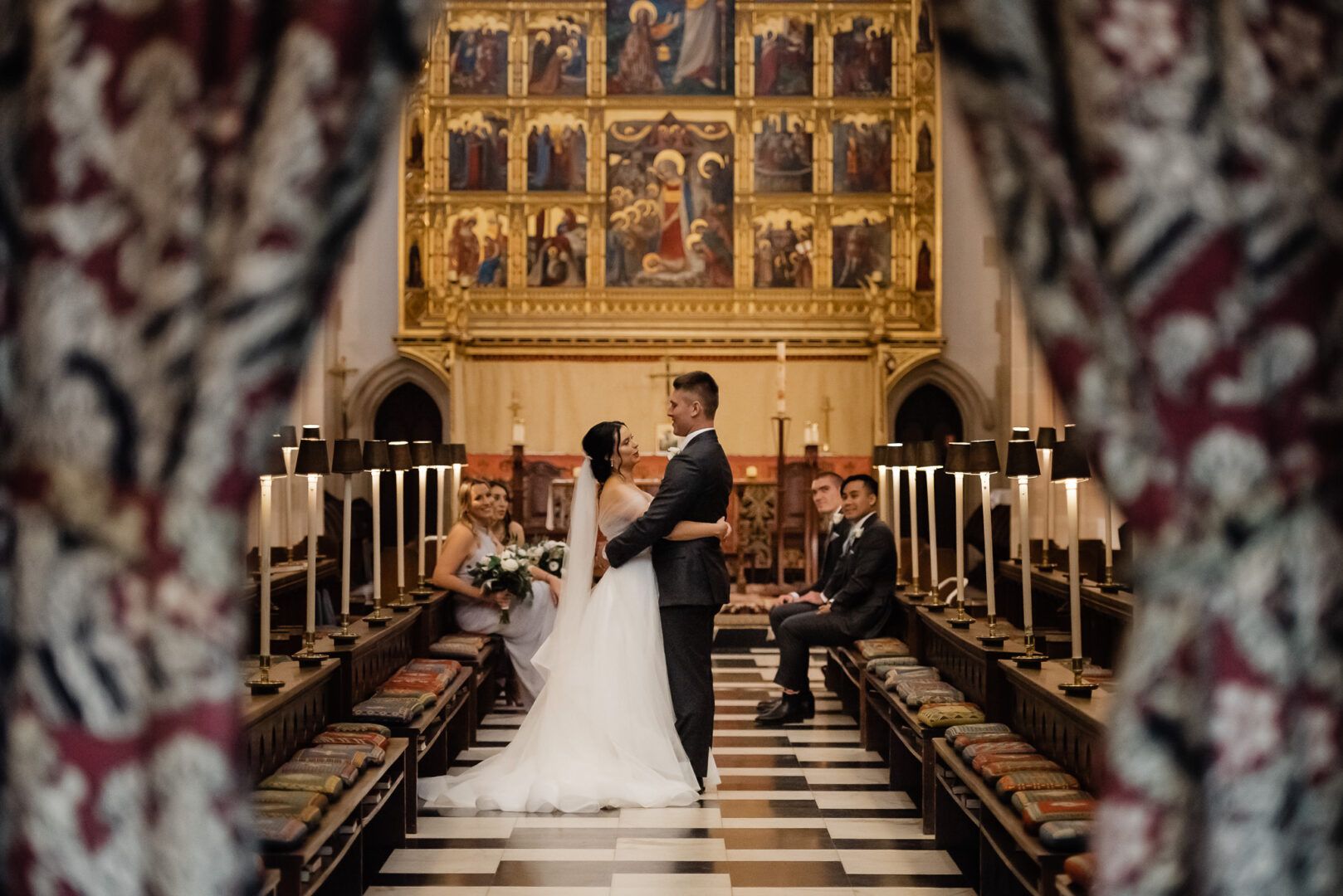 The bride and the groom hold each other tight while standing in the aisle after a wedding at the Guilford Grammar School chapel.