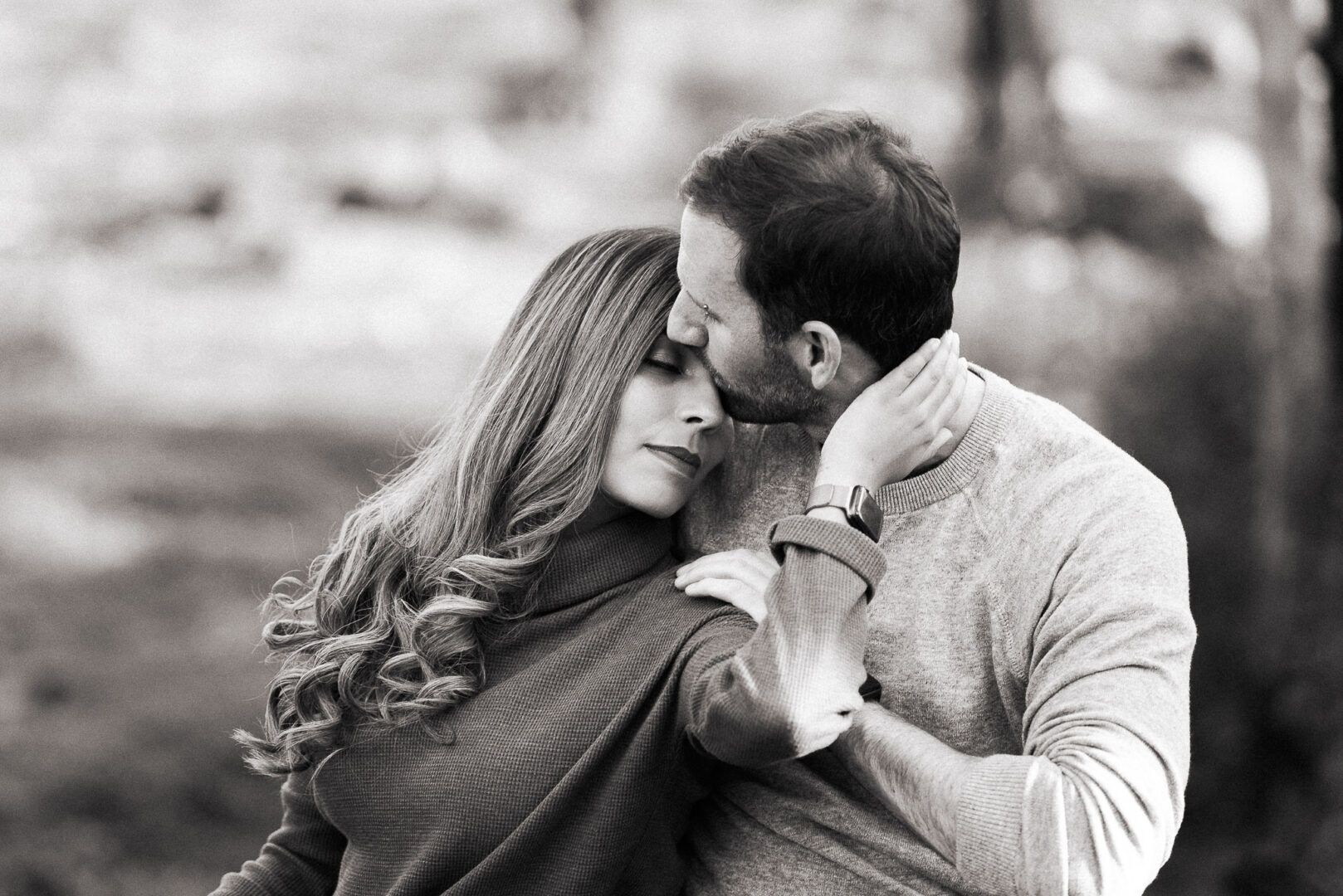 A man kisses his girlfriend on the forehead 